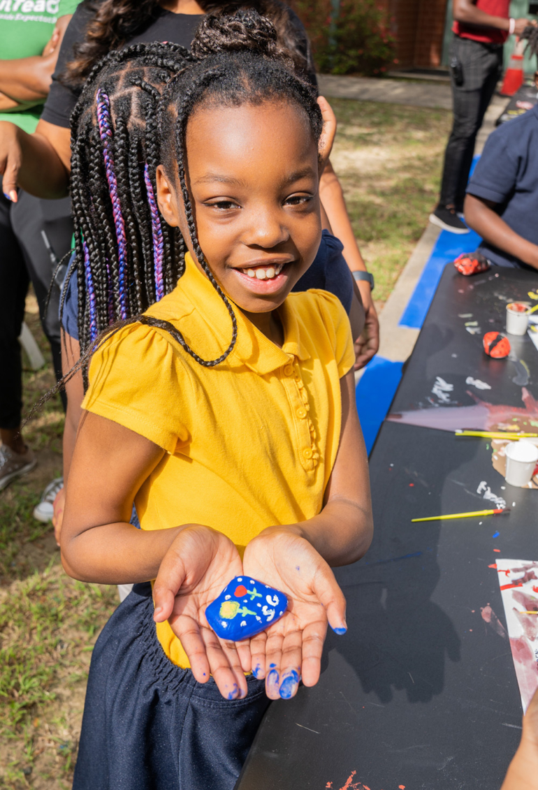 Student holding painted stone