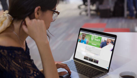 Woman looking at out teach website on computer